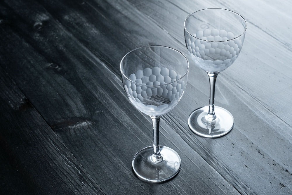 Two crystal glasses on a wooden surface