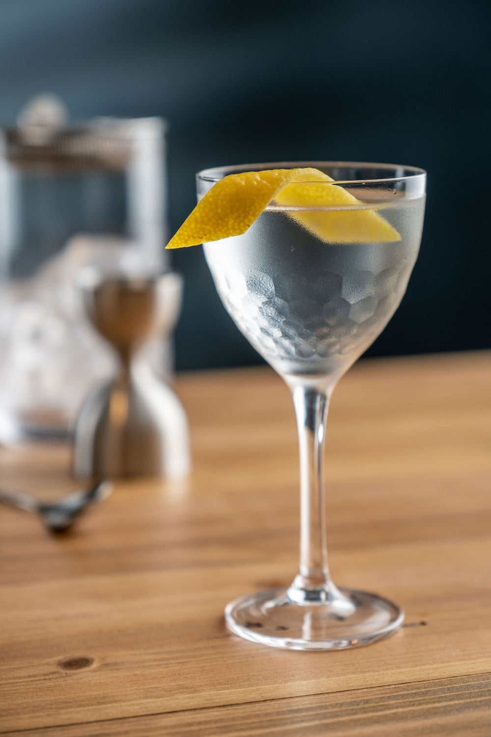 Cocktail in a glass with a lemon twist on a wooden table