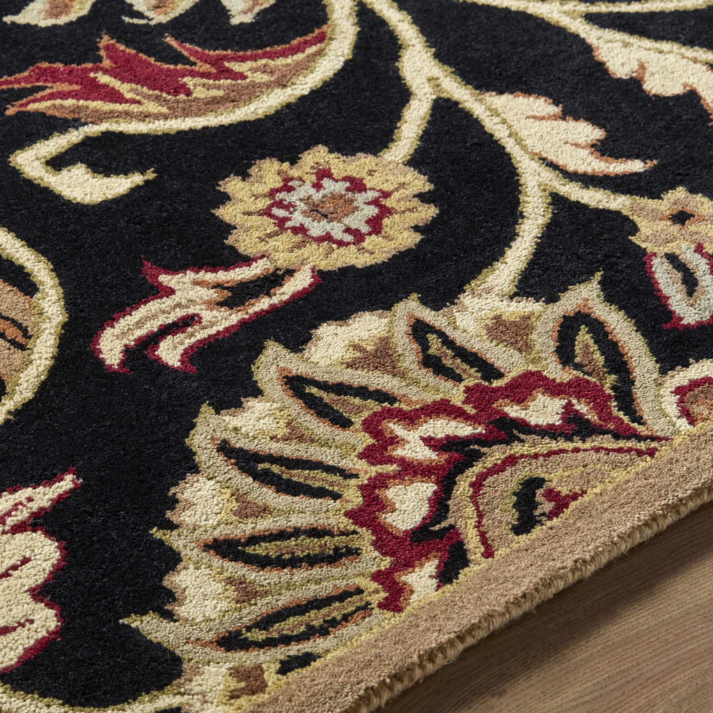 Close-up of an ornate floral rug with intricate patterns on a wooden floor.