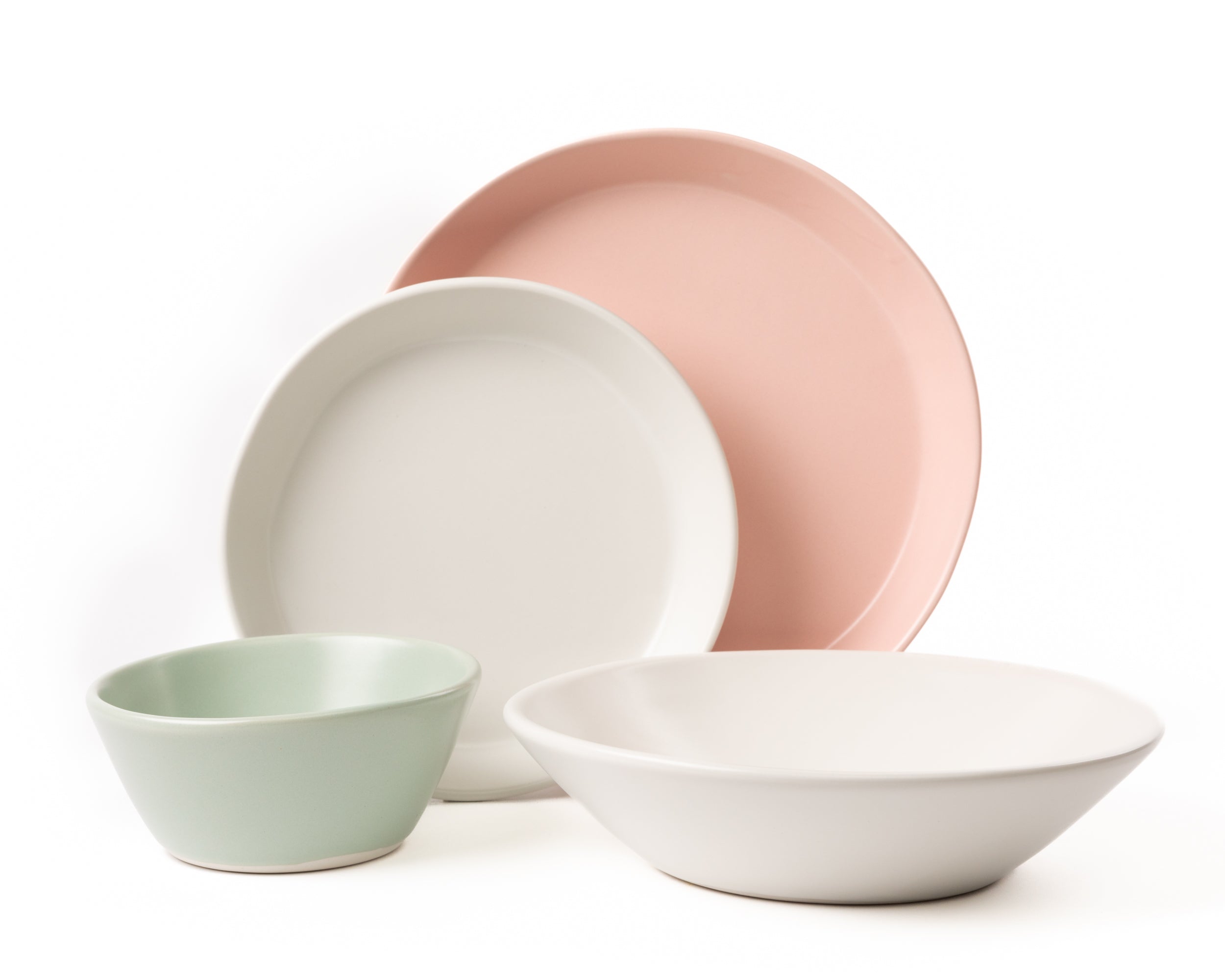 Set of ceramic bowls in pastel colors on a white background