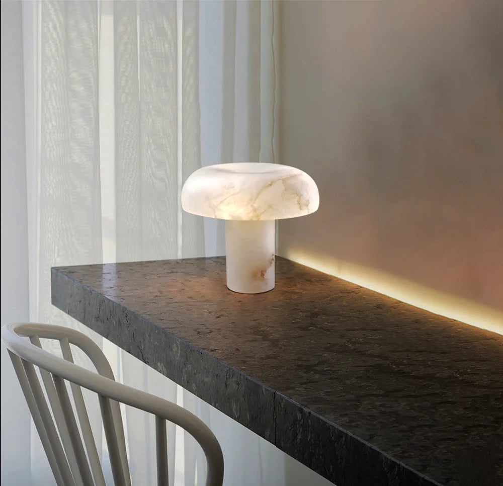 Marble table lamp on a dark surface with a soft light in a minimalistic setting.