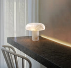 Marble table lamp on a dark surface with a soft light in a minimalistic setting.
