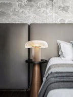 Modern bedroom with a bed, nightstand, and decorative lamp.