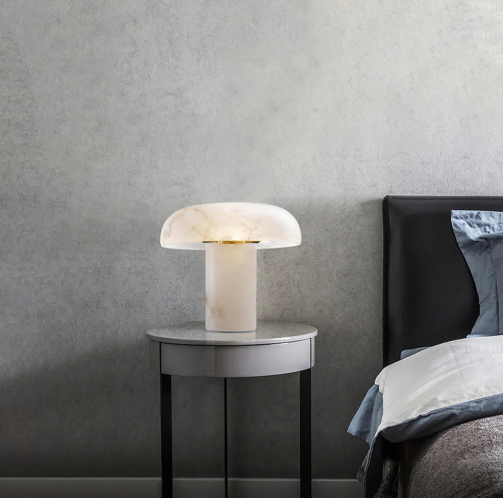 Modern table lamp on a side table next to a bed with a gray wall background