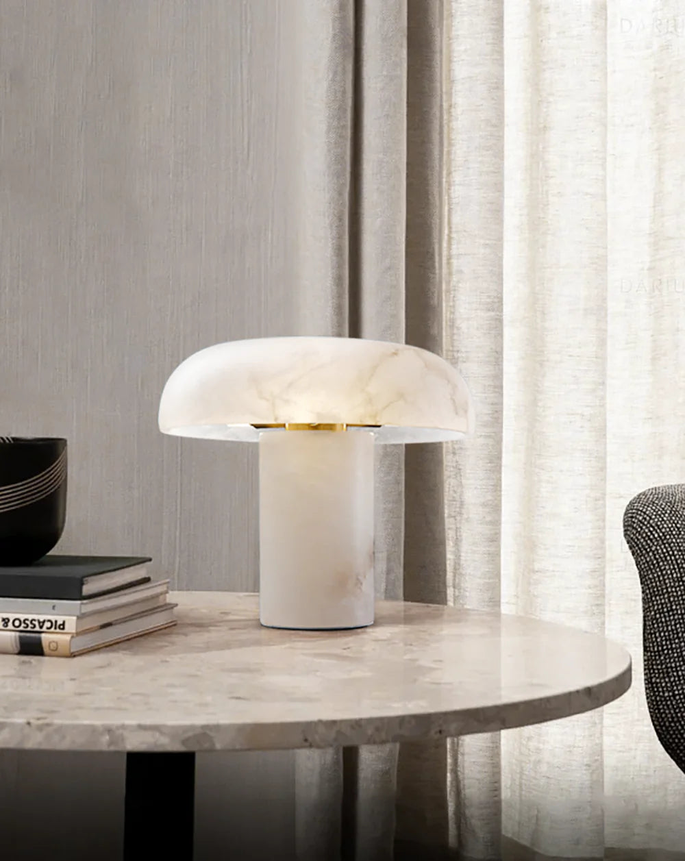Modern table lamp on a marble surface with books and a curtain in the background