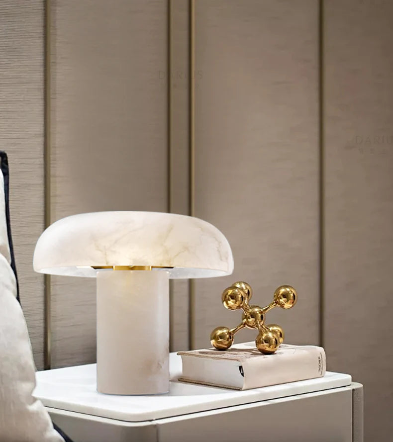 Modern table lamp with marble base on a nightstand against a neutral wall.