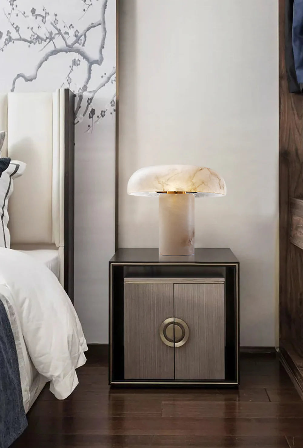 Modern nightstand with a decorative lamp next to a bed in a bedroom setting.