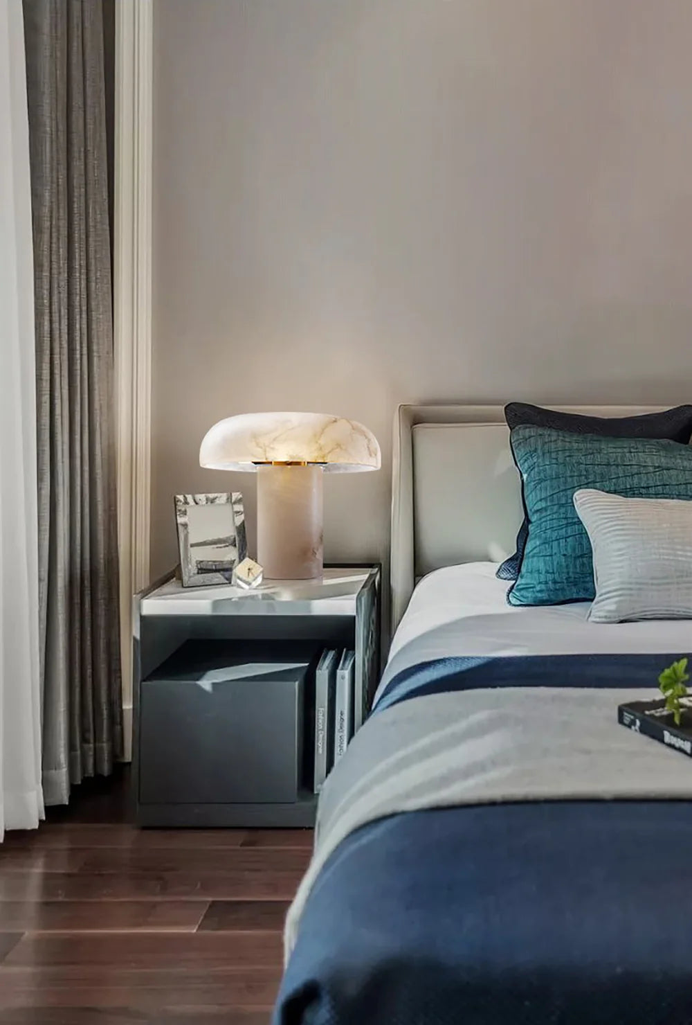 Modern bedroom with a bed, nightstand, and lamp.