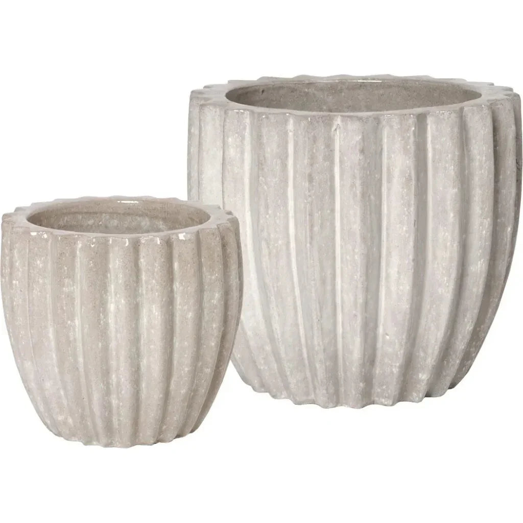 Two ribbed concrete planters on a white background