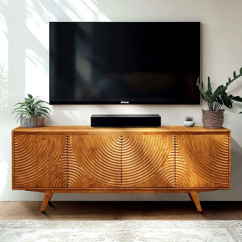 Wooden TV stand with a television and speakers on a white wall background