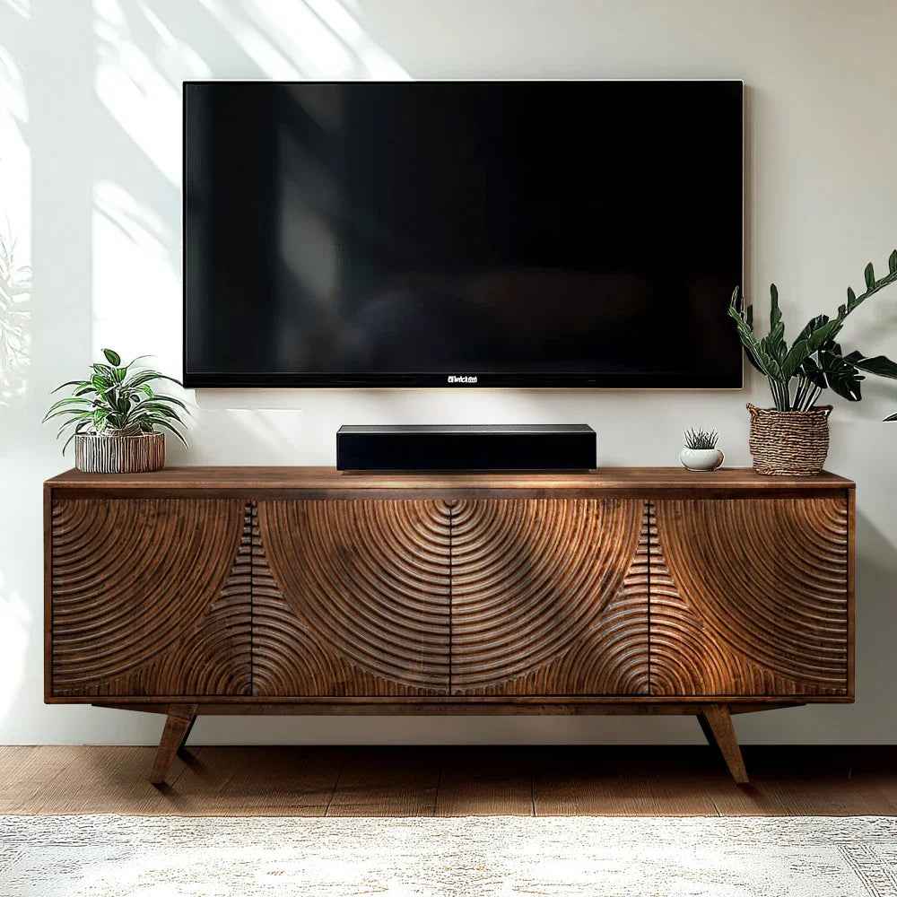 Wooden TV stand with a large screen TV and decorative elements in a room.