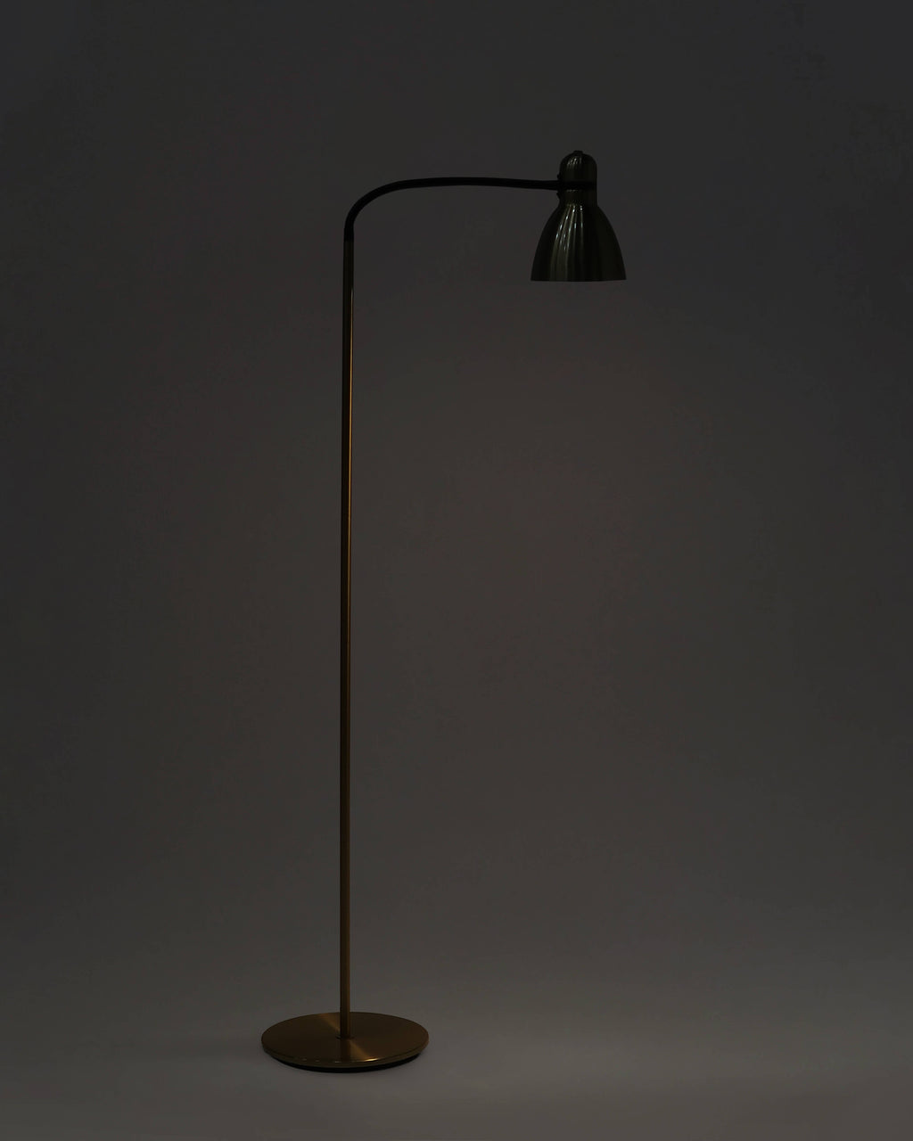 Floor lamp with a black shade on a dark background