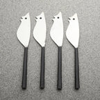 Four metal cheese knives shaped like birds on a gray background