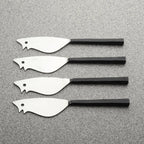 Four metal cheese spreaders with black handles on a gray surface