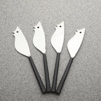 Four metal bird-shaped knives on a gray surface