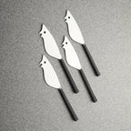 Four metal bird-shaped tools on a gray surface