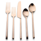 Set of rose gold cutlery including fork, knife, and spoons on a white background