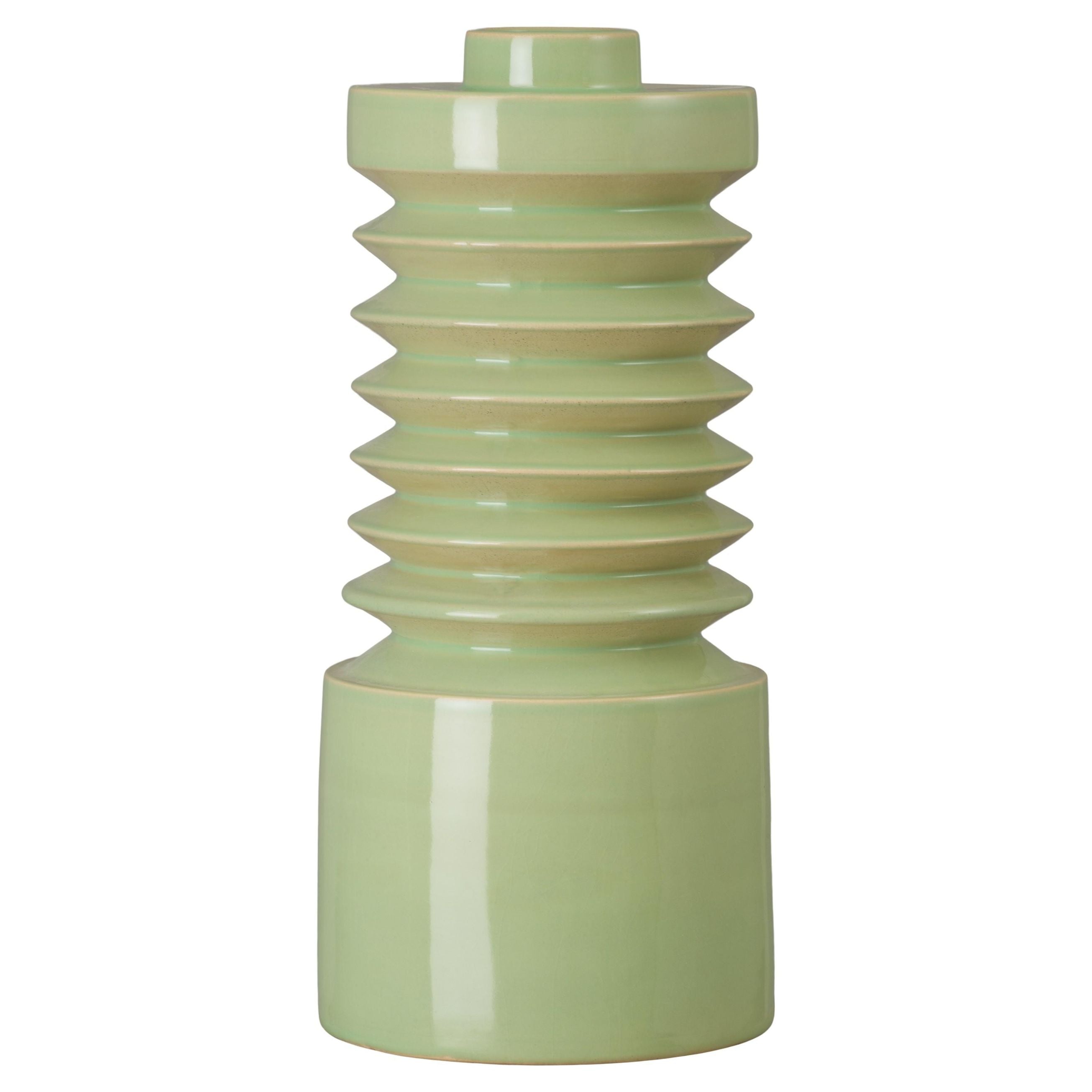 Green ceramic vase with ribbed design on a white background