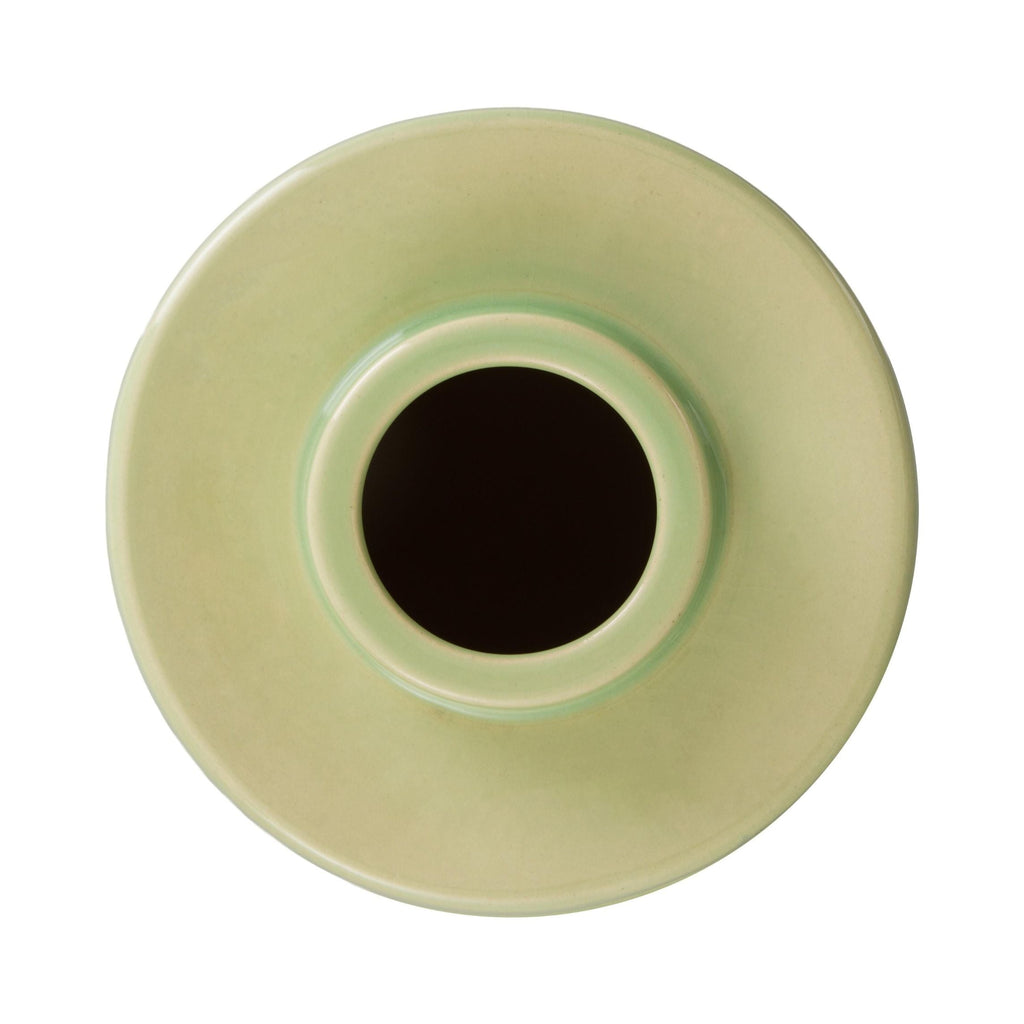 Top view of a light green ceramic vase with a central black circle on a white background
