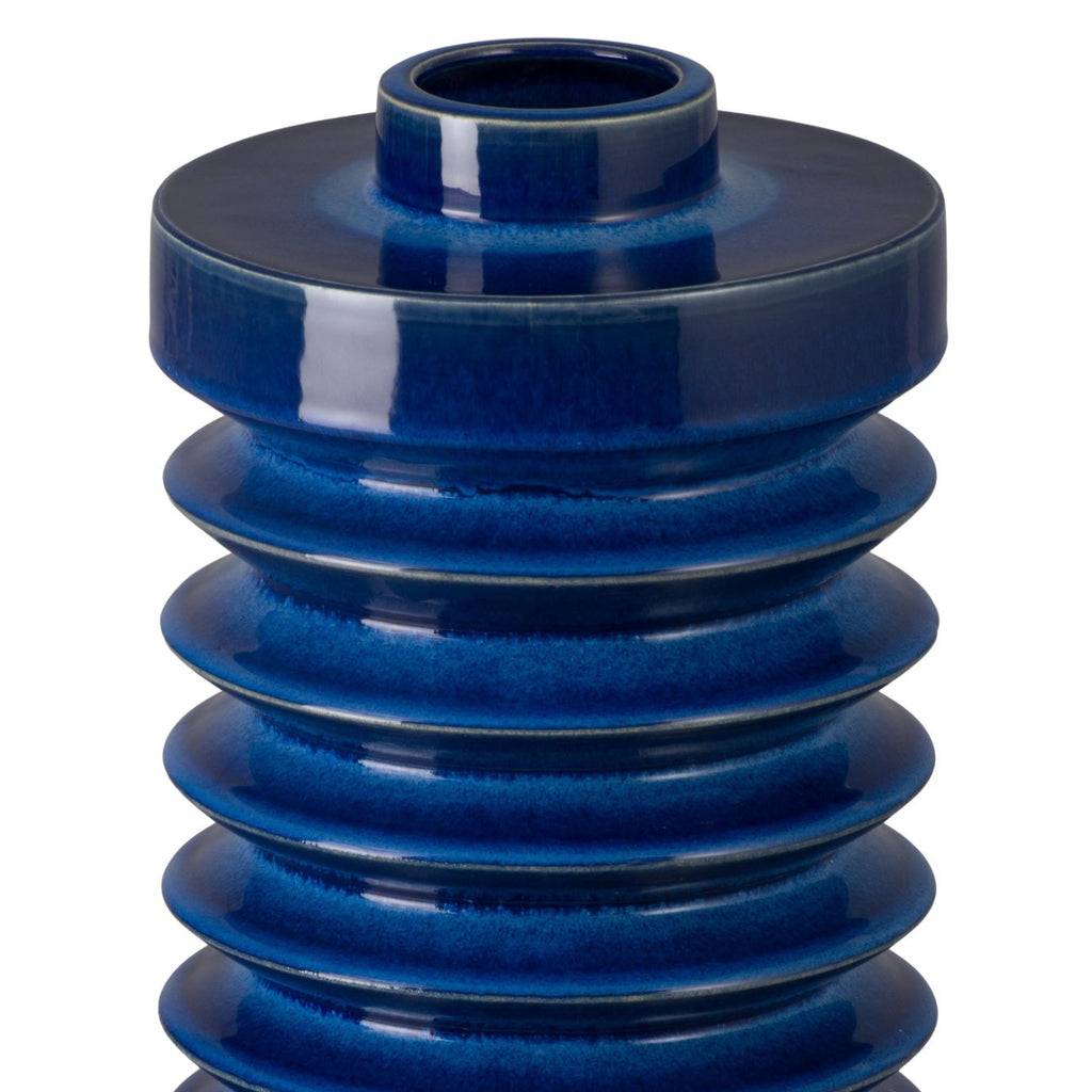 Blue ceramic vase with layered design on a white background