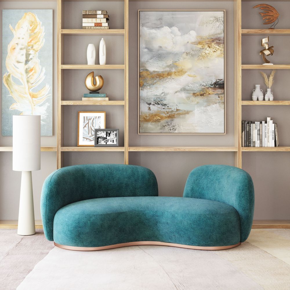 Modern teal sofa in a stylish living room with bookshelves and abstract art.