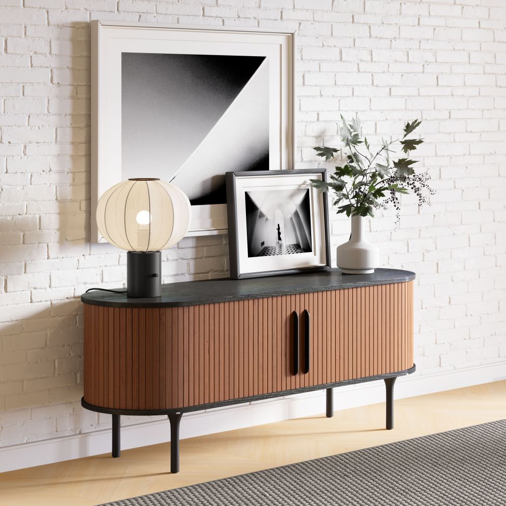 Wooden sideboard with decorative items against a white brick wall