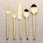 Set of gold cutlery on a textured beige background