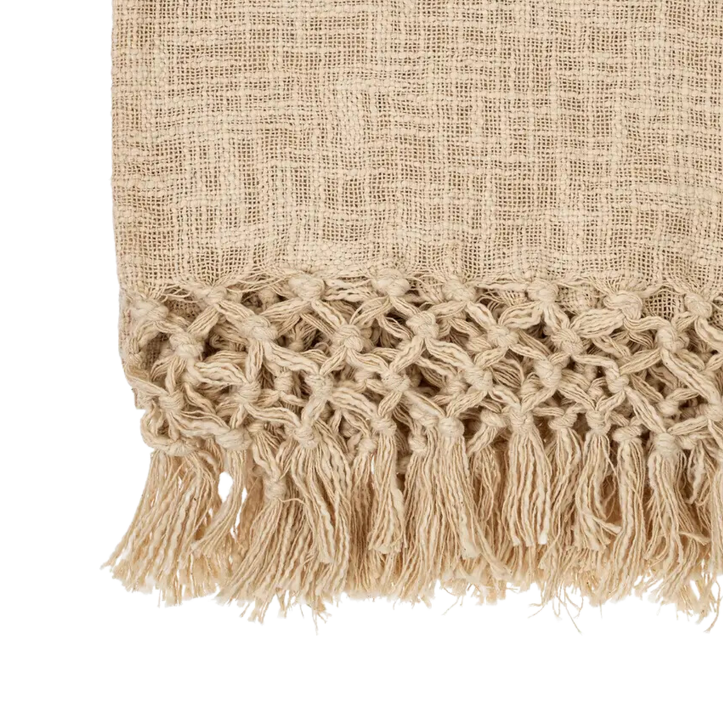 Textured fabric with woven pattern and tassels on a white background
