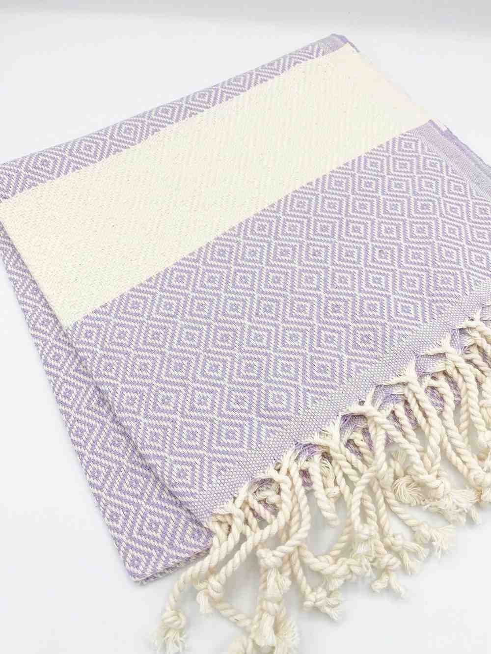 Lilac diamond-pattern hand towel with white fringe and geometric design on white background