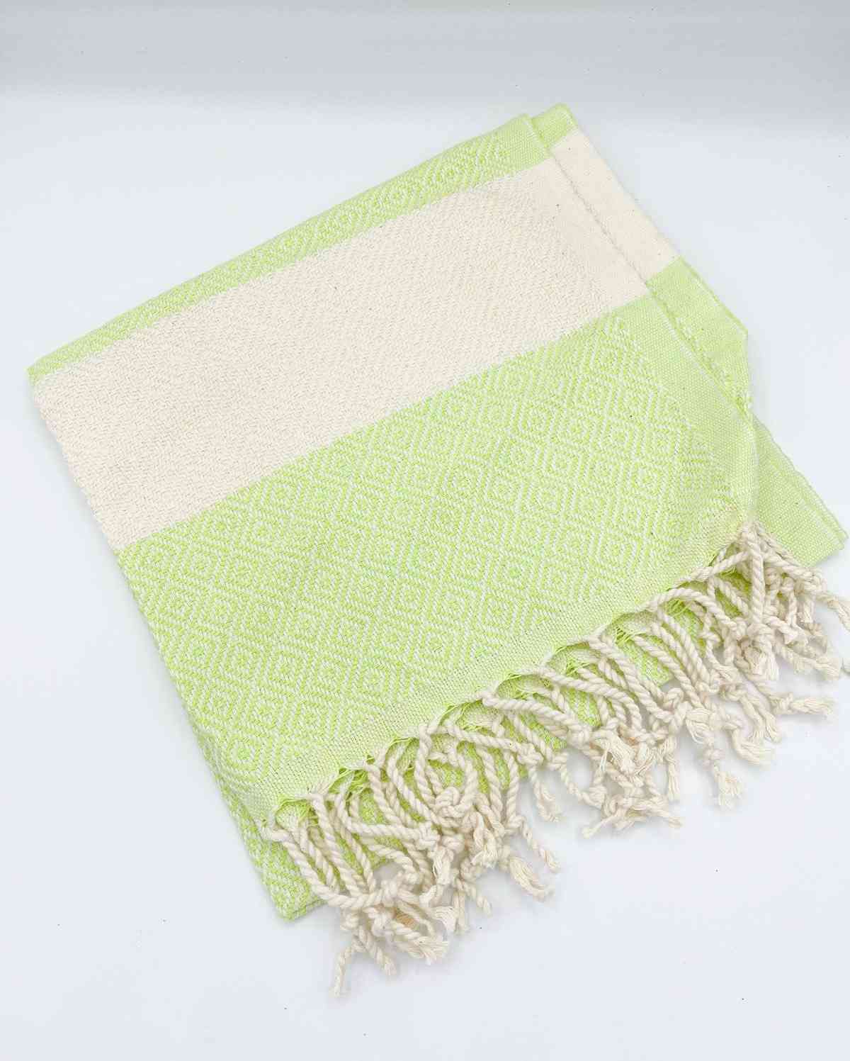 Lime green diamond-patterned hand towel with cream stripes and fringe on white background