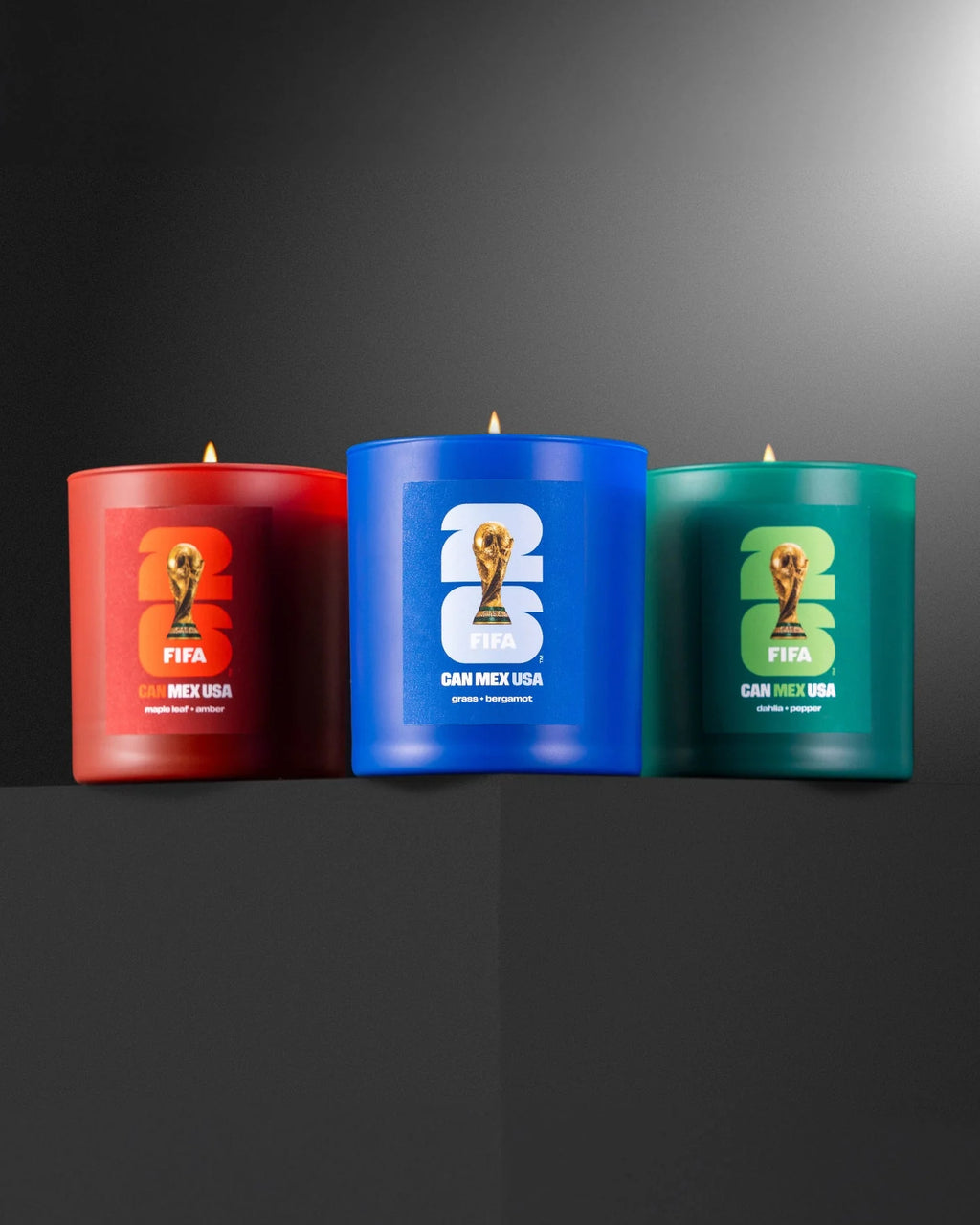 Three candles in red, blue, and green with FIFA World Cup logos on a dark background