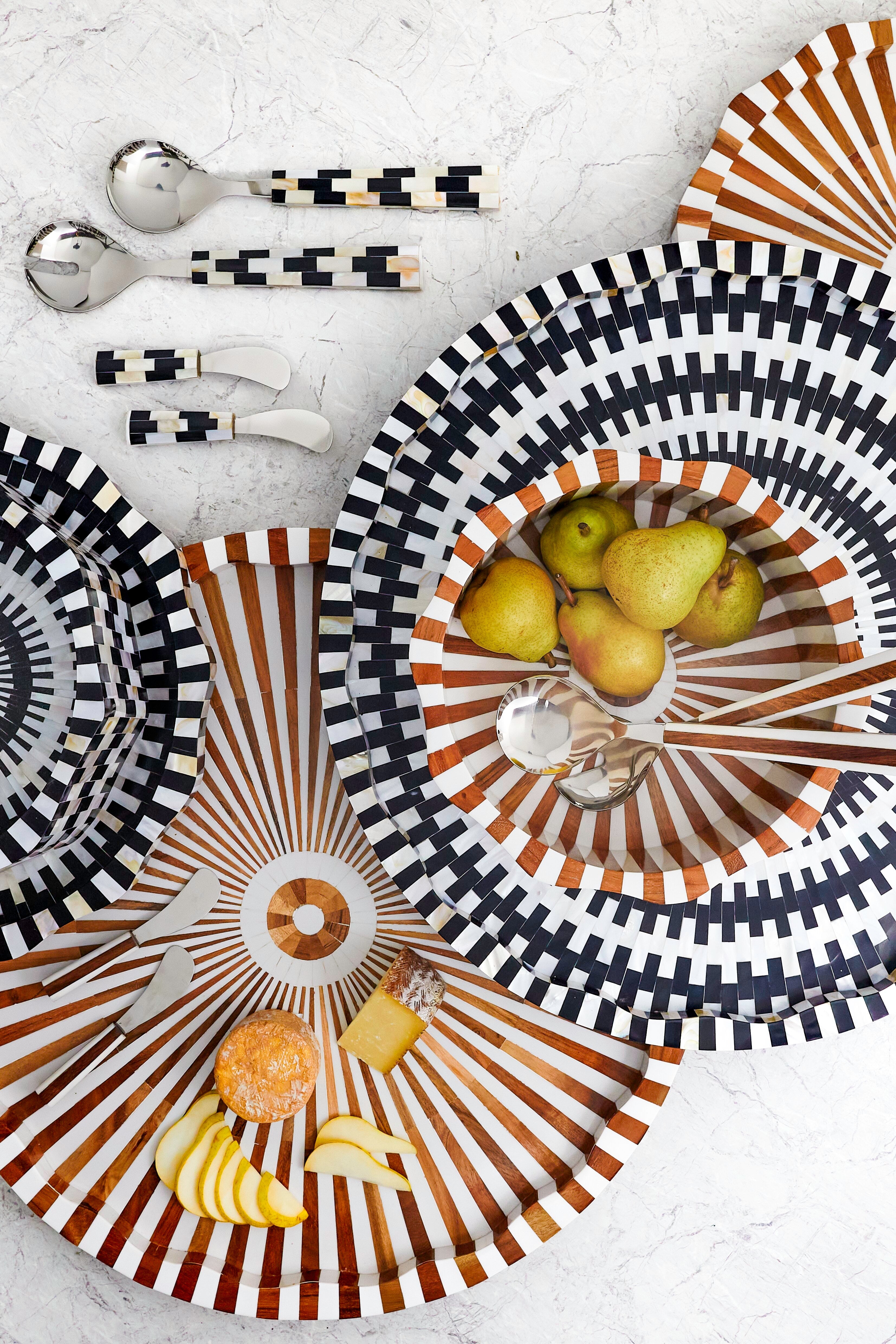 Decorative plates with striped patterns and fruit on a light background