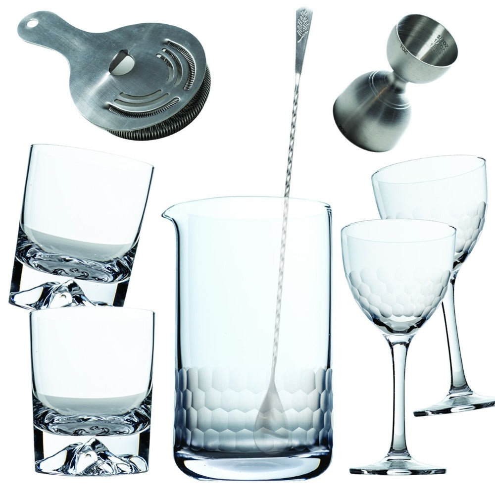 Set of cocktail glasses and bar tools on a white background