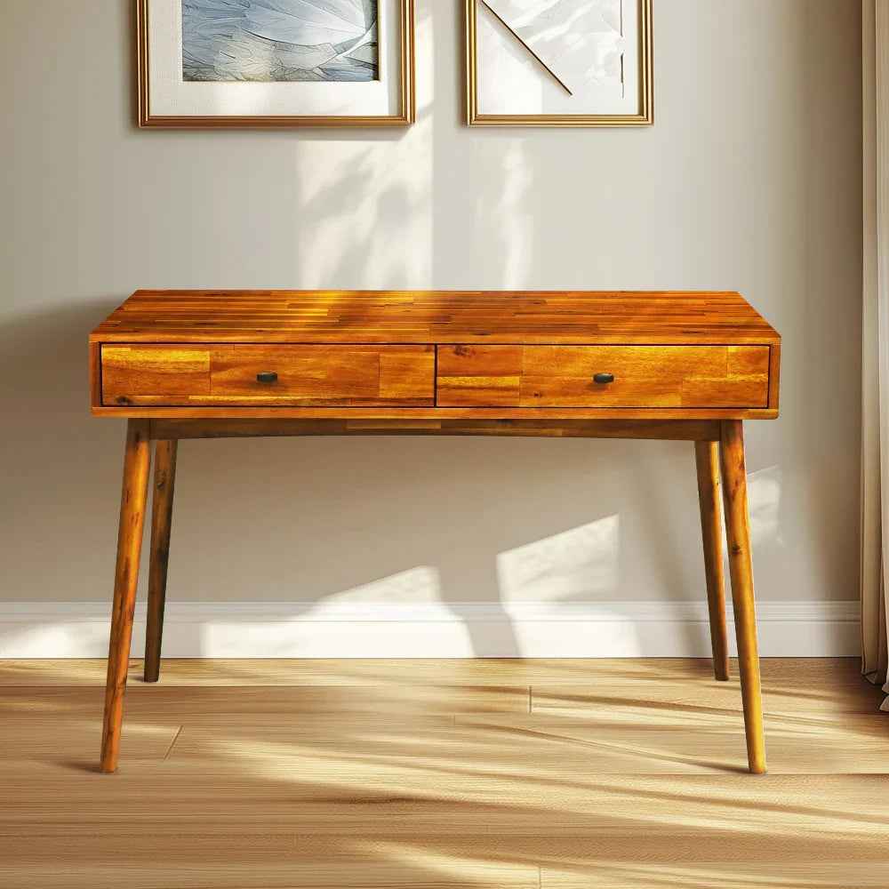 Wooden desk with two drawers in a room with light-colored walls and wooden floor.