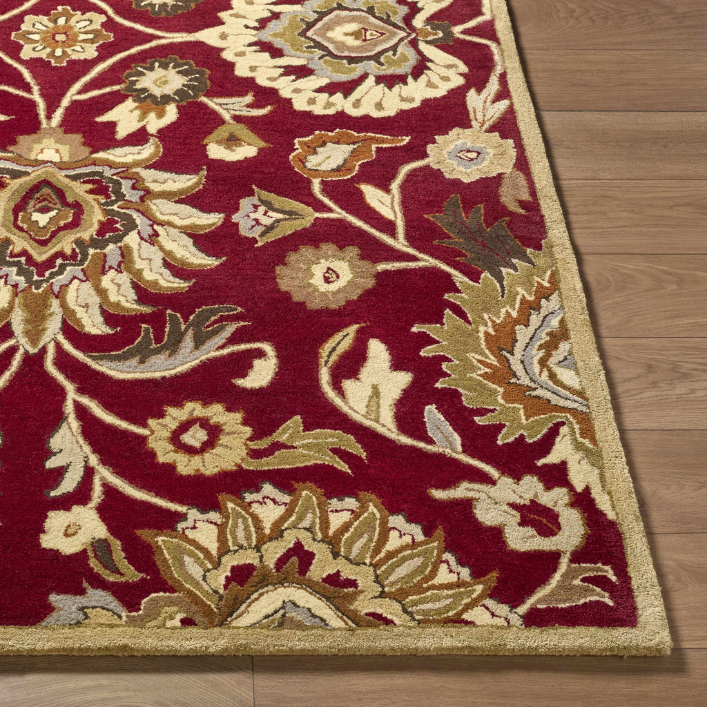Decorative red and beige floral rug on a wooden floor
