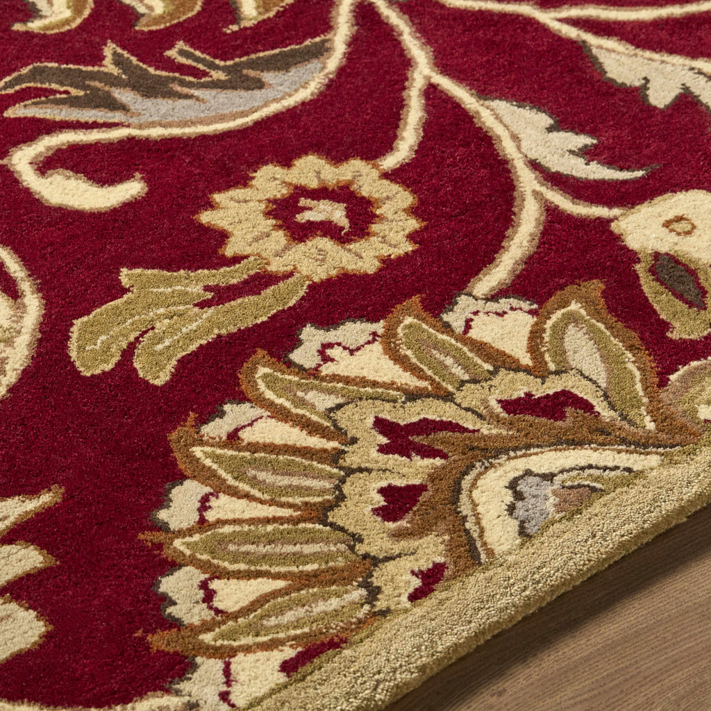 Close-up of a red and beige floral patterned rug.