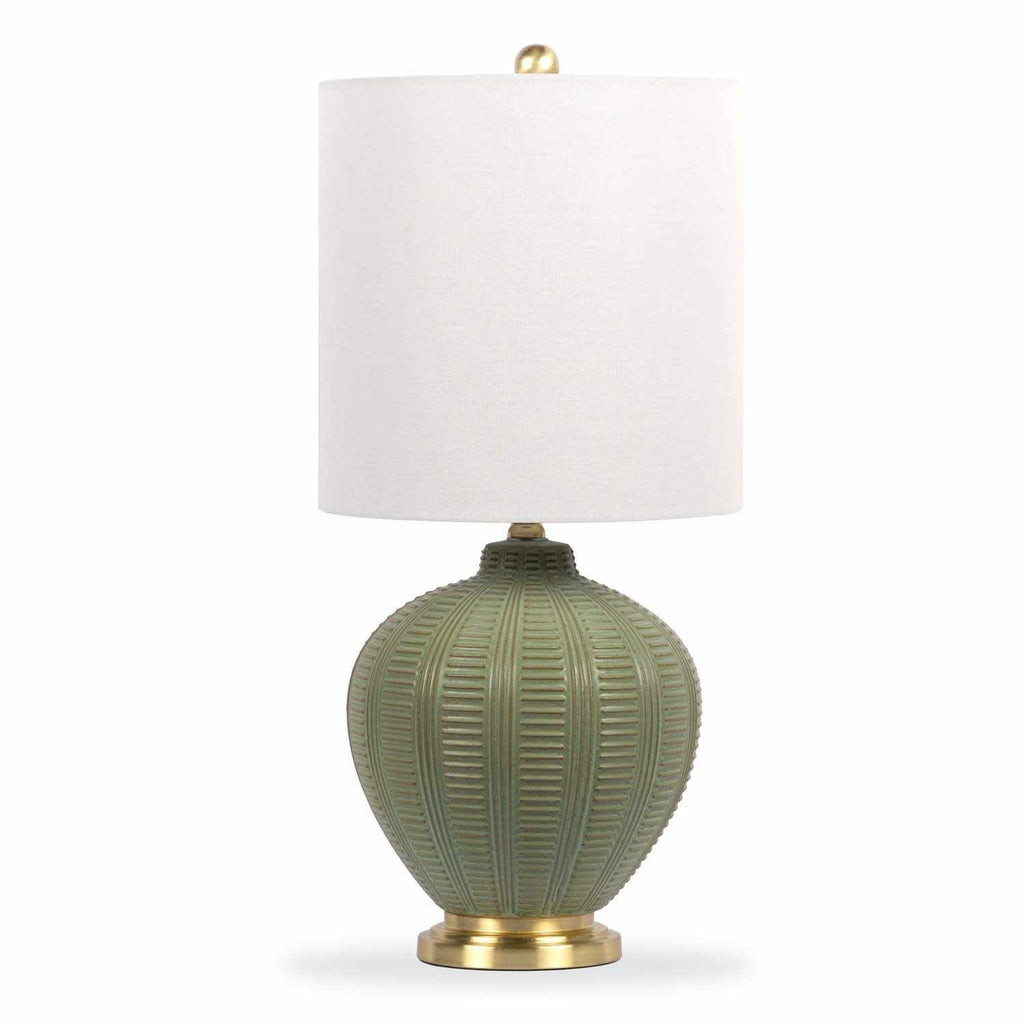 Table lamp with green ceramic textured base and white shade on a white background