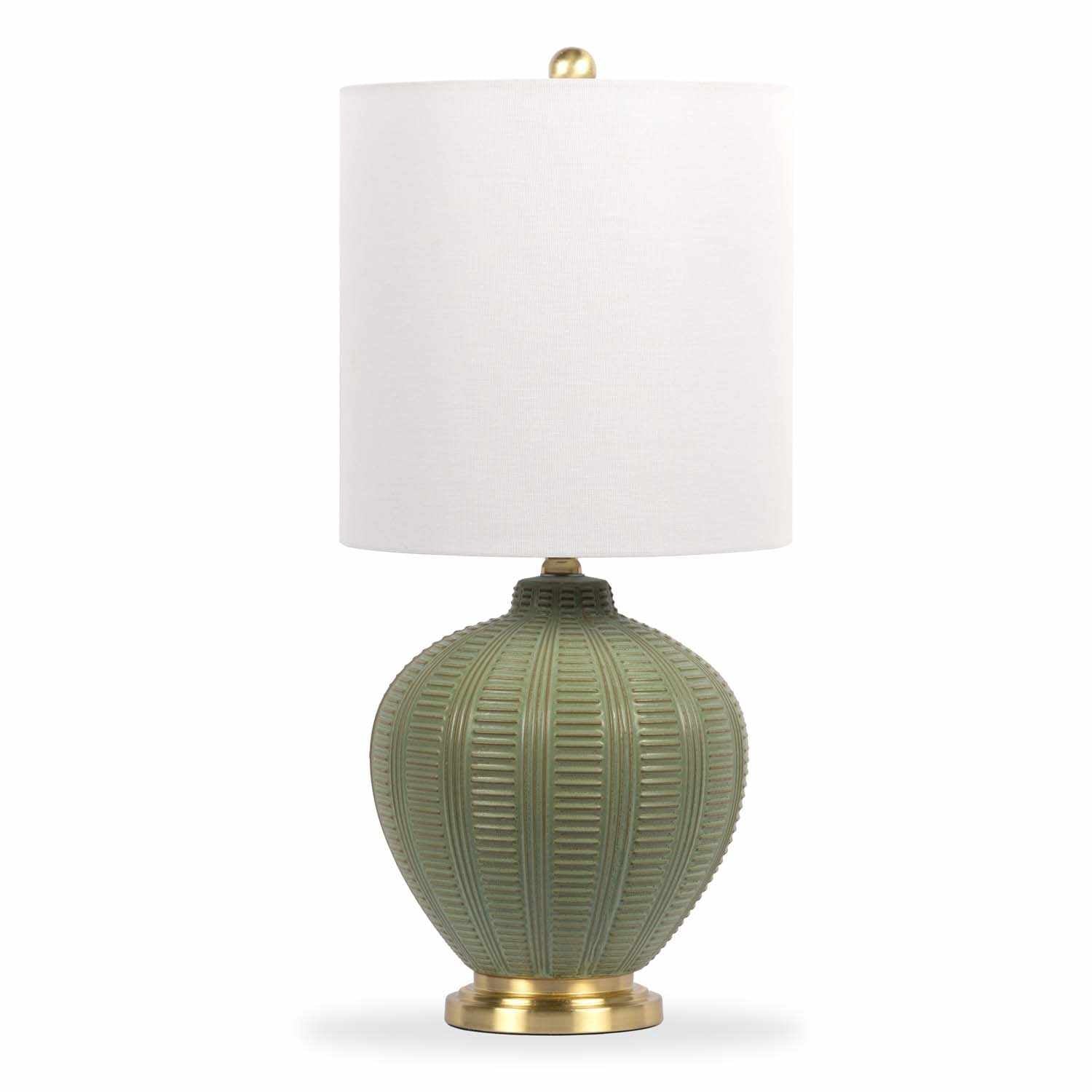Table lamp with green ceramic textured base and white shade on a white background