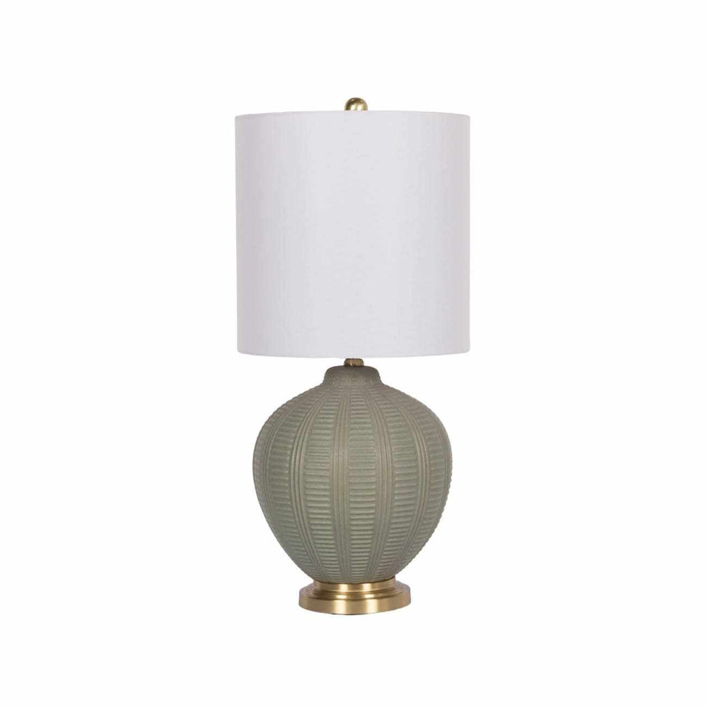 Table lamp with textured green base and white shade on a white background
