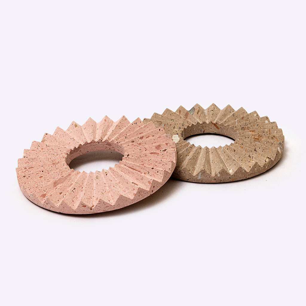 Two stone washers with textured surfaces on a white background
