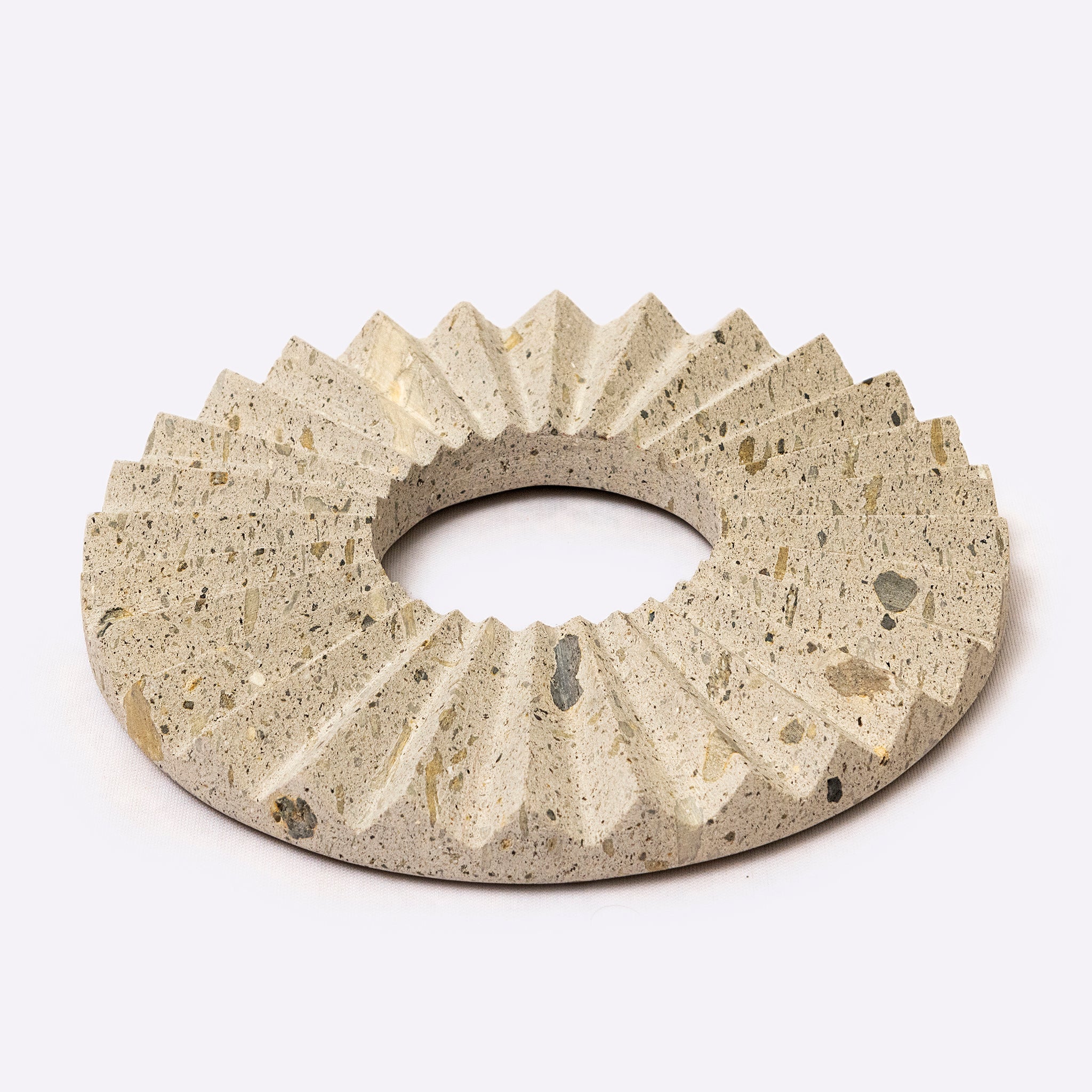 Concrete ring trivet with textured surface on a white background