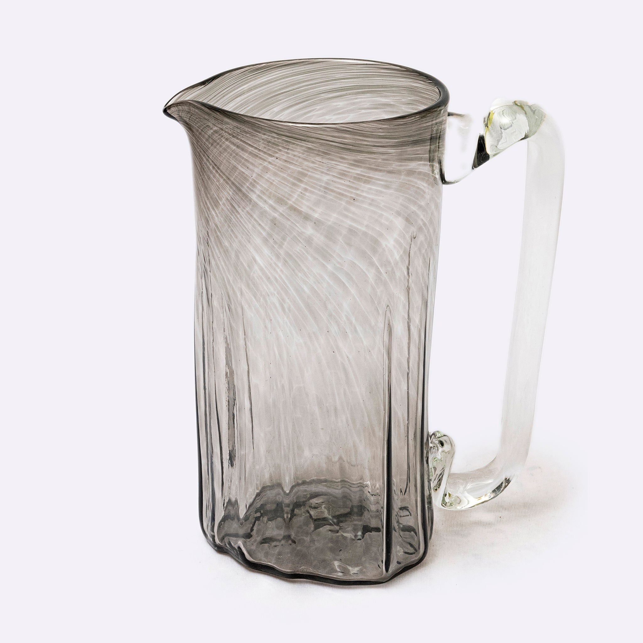 Glass pitcher with textured design on a white background