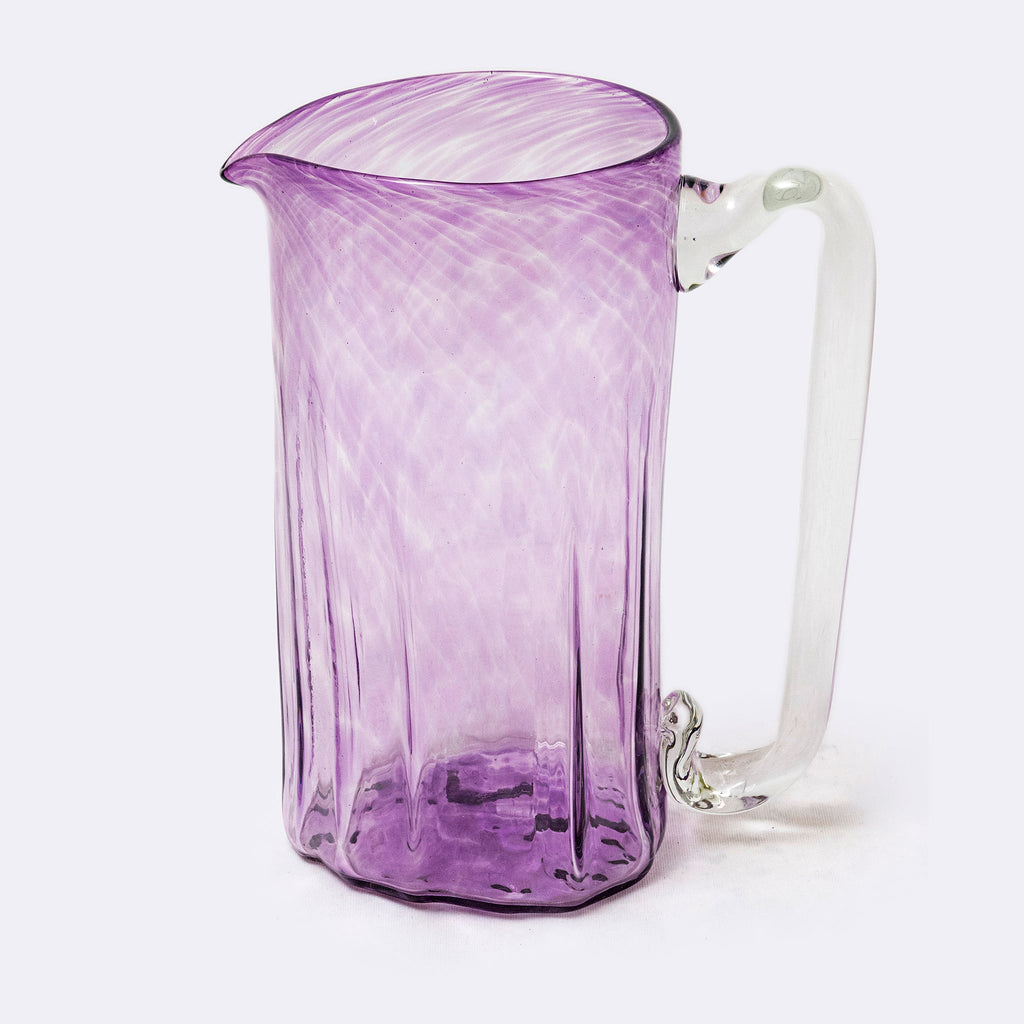 Purple glass pitcher on a white background