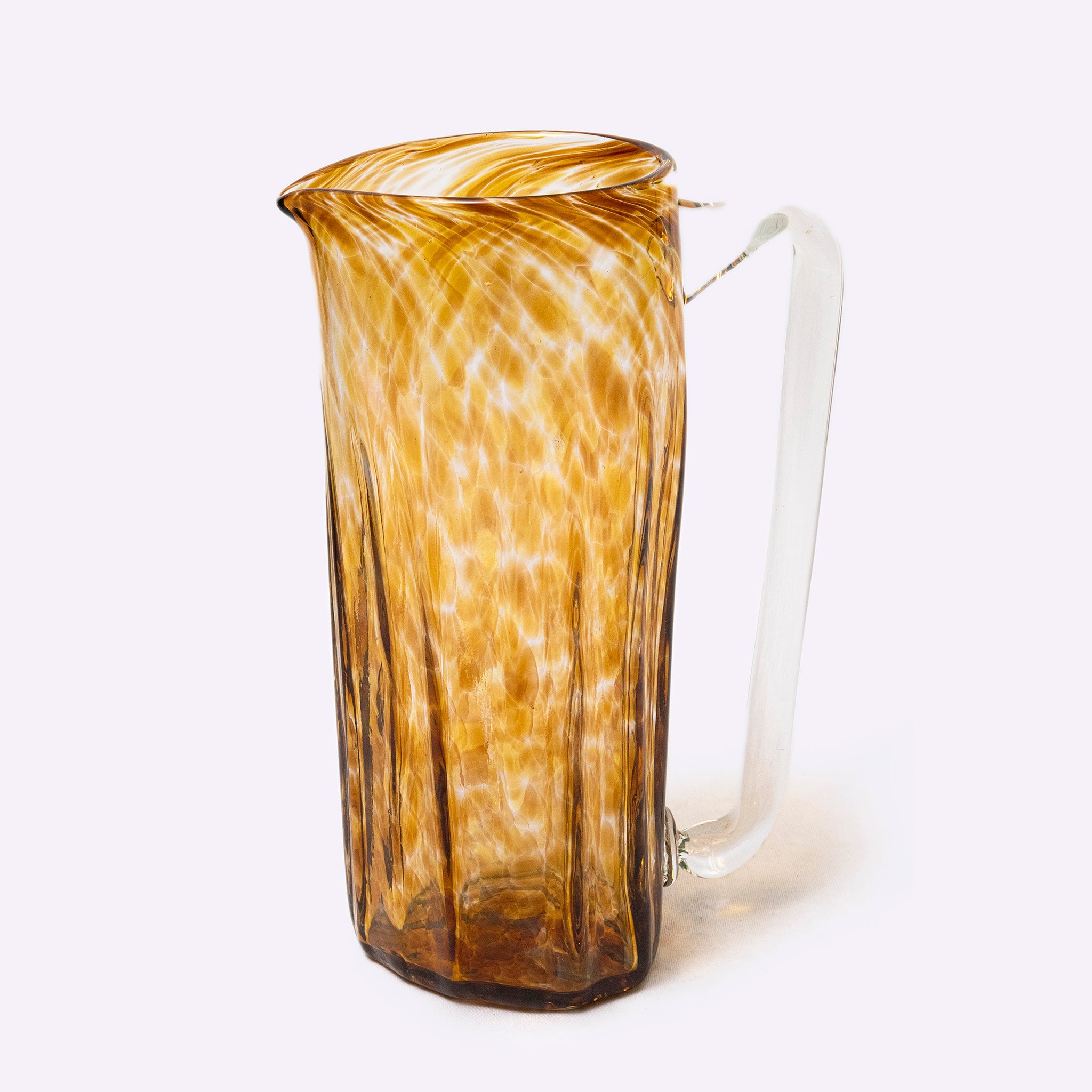 Glass pitcher with brown and white marbled design on a white background