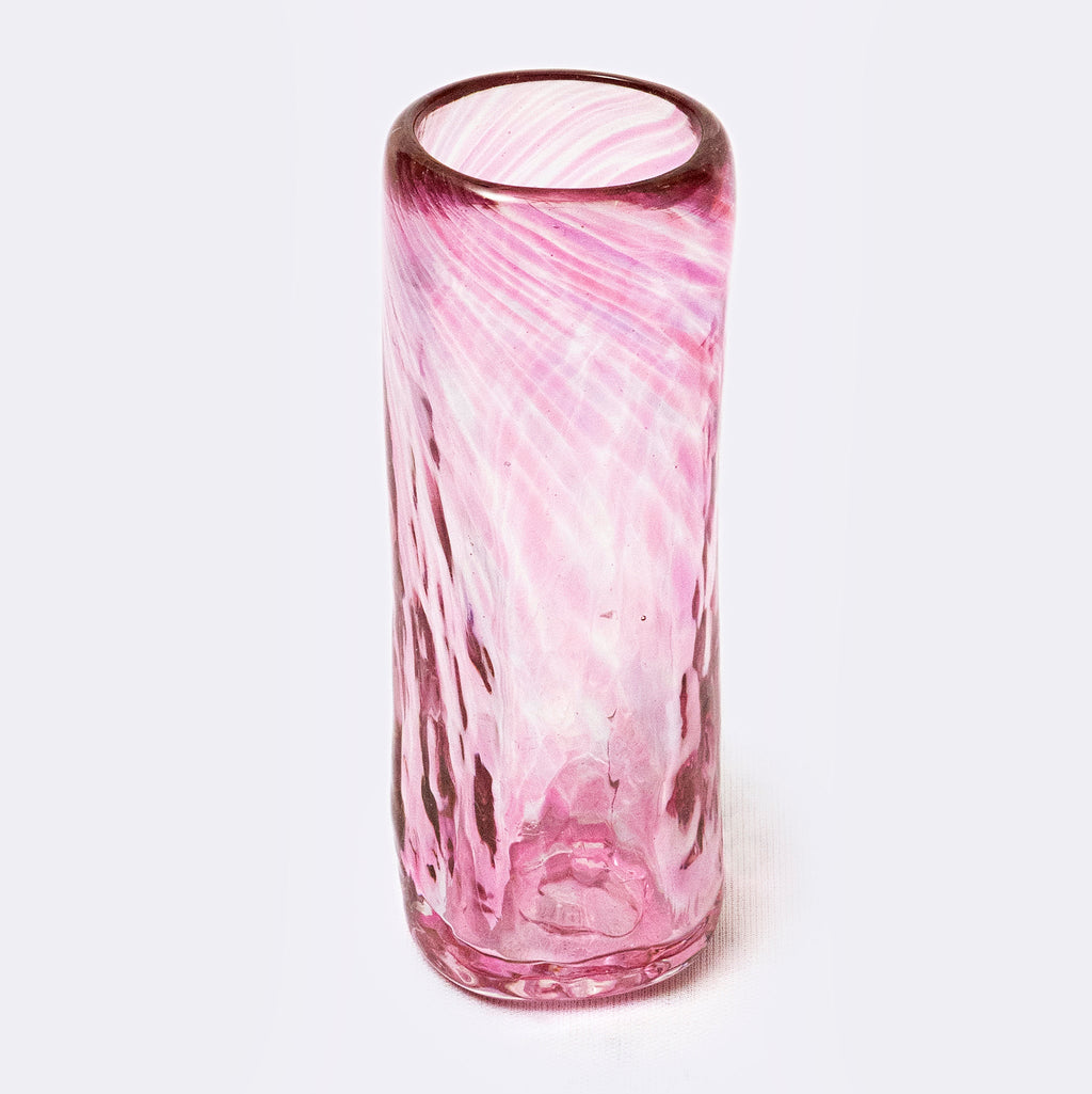 Pink glass vase with a textured design on a white background