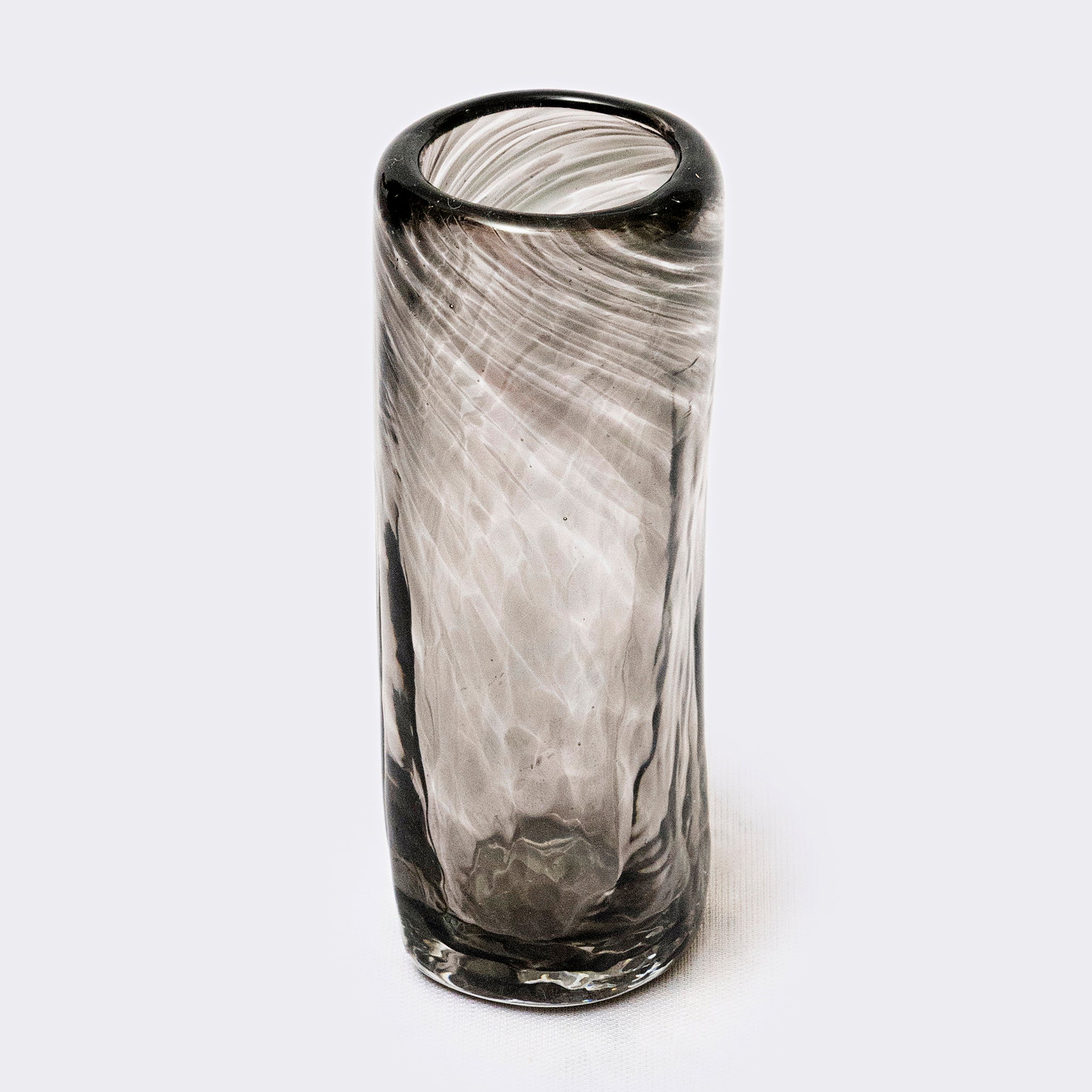 Tall cylindrical glass with black rim on a white background
