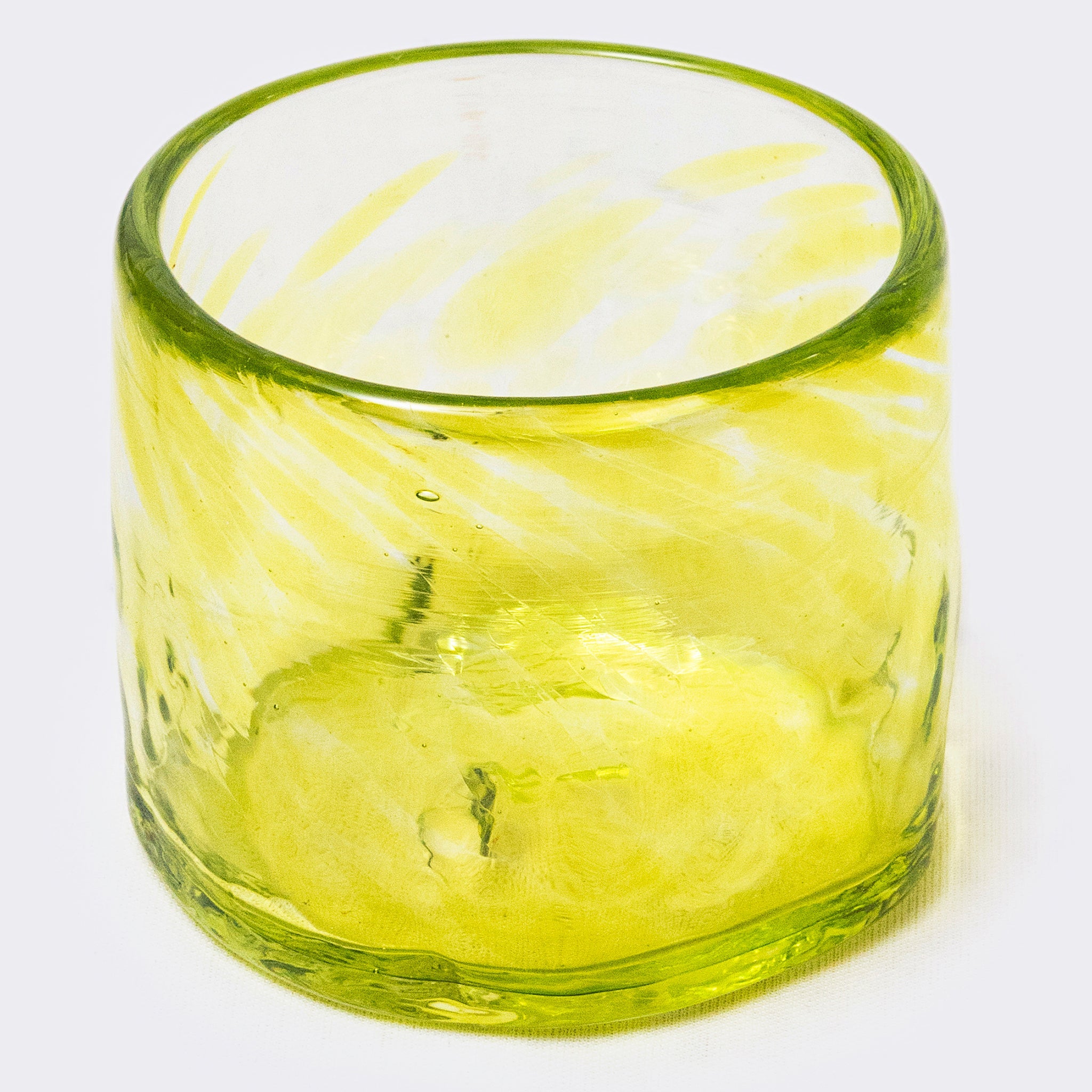 Green glass tumbler on a white background