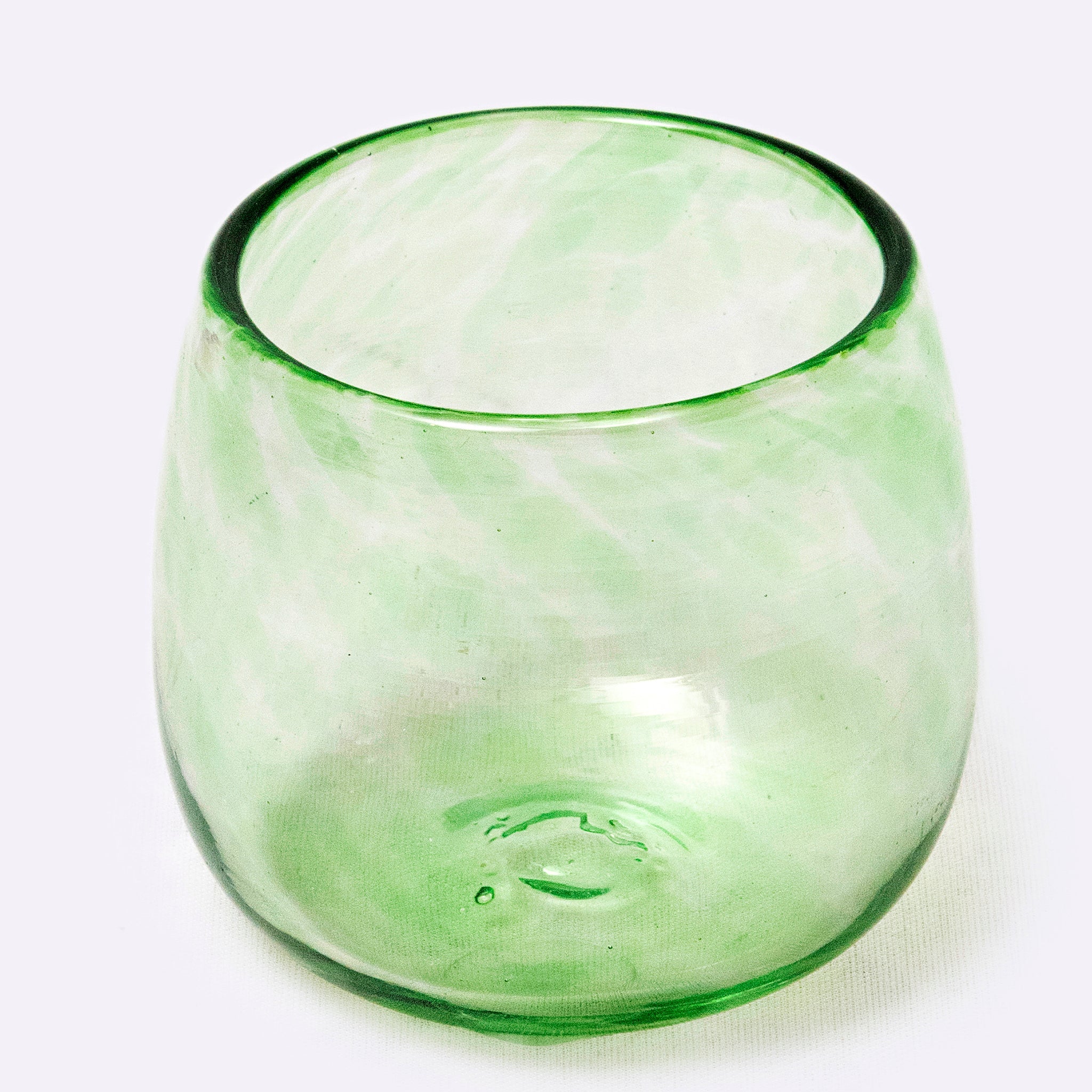 Green glass tumbler on a white background