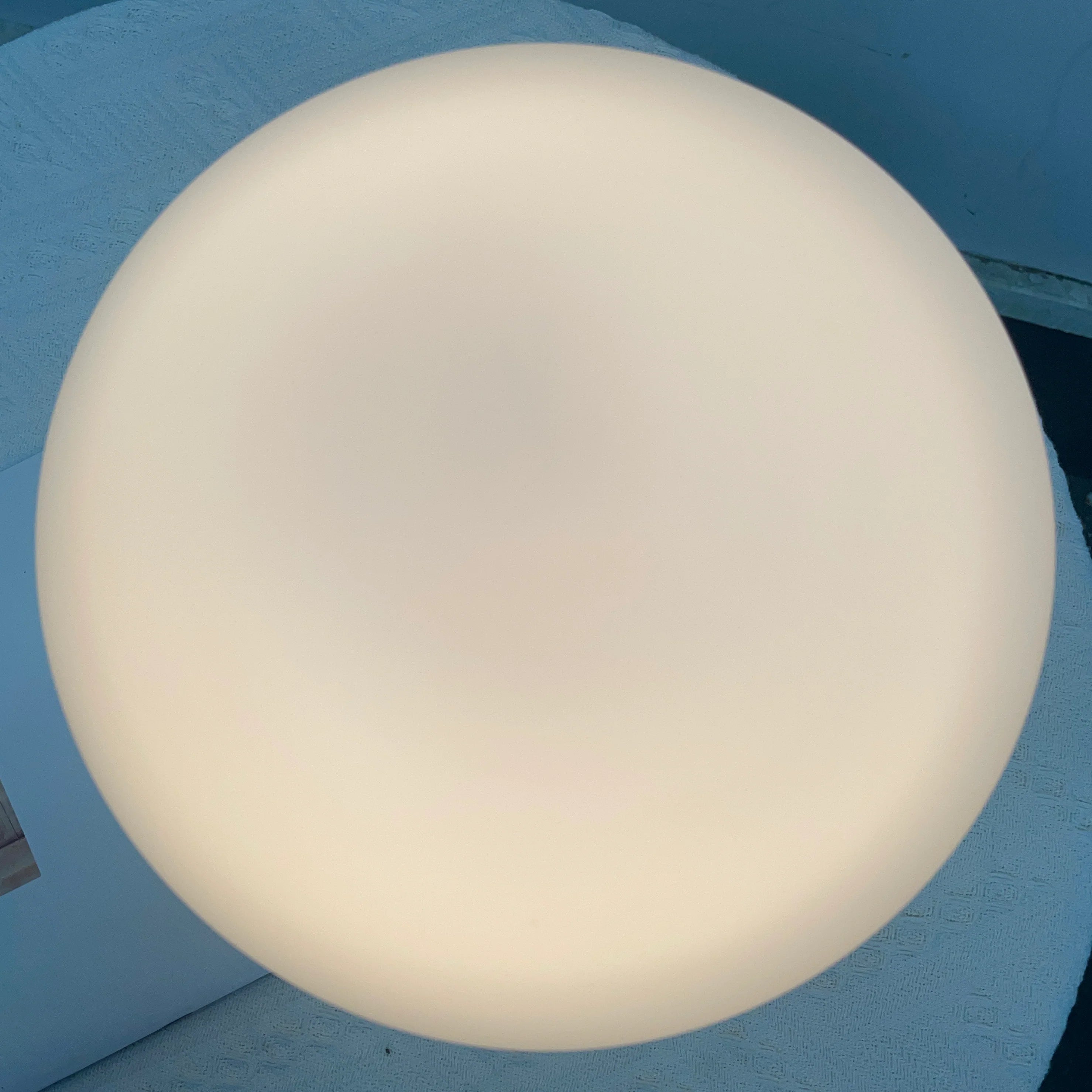 Large white spherical object against a blue background