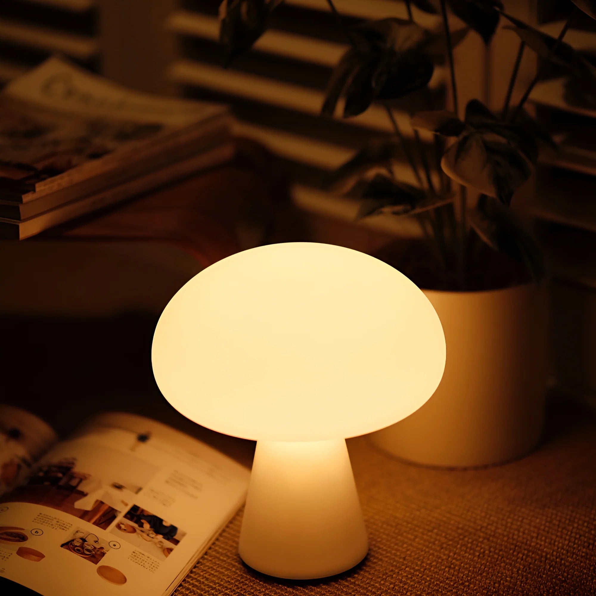 Mushroom-shaped night light on a table with a magazine and plant in the background